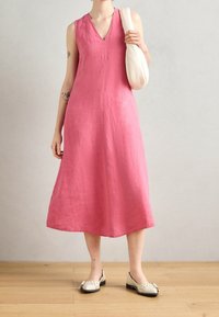 Rosa Leinen ärmelloses Kleid mit V-Ausschnitt, fließender A-Linie-Silhouette, gesäumtem Saum, kombiniert mit cremefarbenen Ballerinas und einer weißen Tasche.