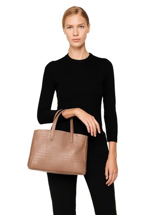 Borsa a spalla beige con effetto coccodrillo, forma rettangolare e texture liscia, tenuta da una persona con una maglietta nera.