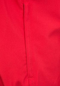 Rode textielstof met een gestructureerd oppervlak met verticale lijnen en een naad in het midden. Geen andere details of patronen aanwezig.