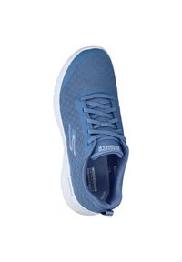 Blå atletisk sko med en strukturerad mesh-övre, snörning framtill, vadderad krage och en vit gummisula. Har varumärkets logotyp på sidan.
