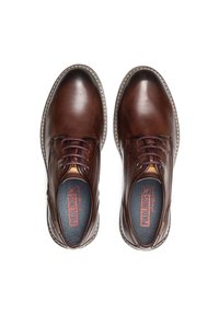 Chaussures en cuir marron avec un bout rond, un design à lacets, des coutures contrastées et des semelles intérieures texturées arborant un logo rouge et noir.