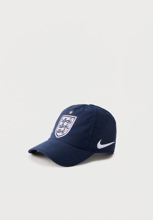Casquette de baseball bleu marine avec l'écusson de football d'Angleterre et une étoile dorée au-dessus, avec un swoosh blanc Nike sur le côté.