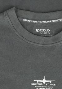 Donkergrijze katoenen t-shirt met ronde hals, met witte tekst "CABINE CREW PREPARE FOR DEPARTURE" en een vliegtuiggraphic.