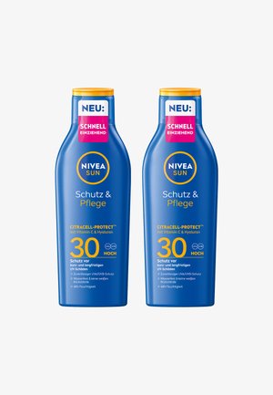 Two blue Nivea Sun Schutz & Pflege SPF 30 sunscreen bottles with orange caps and labels highlighting fast absorption and UVA/UVB protection.