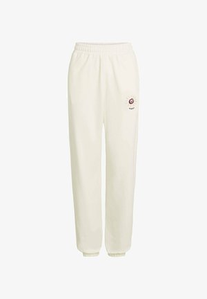 Krémové tepláky s elastickým pásom, zúženými manžetami a malým vyšívaným slnečným logom v bordovej a béžovej farbe na ľavom stehne.