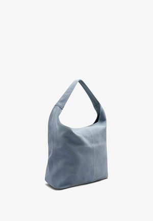 Zachte blauwe suède schoudertas met een brede riem en een nonchalante, rechthoekige lichaamsvorm, rechtopstaand op een witte achtergrond.