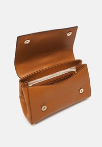 Bruine leren tas met een gladde textuur, voorzien van een gouden drukknoopsluiting en twee compartimenten, waarvan één met een ritsvak aan de binnenkant.