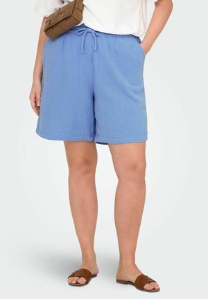 Lysblå, teksturerede bomulds shorts med elastisk talje og snøre. Parret med brune, vævede slidesandaler.