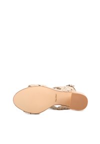 Sandalo intrecciato beige con fondo piatto e liscio, dotato di cinturini intrecciati e chiusura con fibbia. Leggero logo del marchio sulla suola.