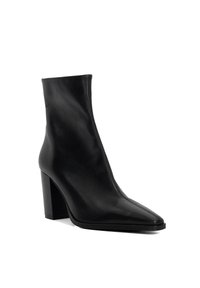 Bottine en cuir noir avec un bout pointu, un talon bloc haut et un détail de fermeture éclair élégante à l'avant. Texture lisse sur l'ensemble du design.