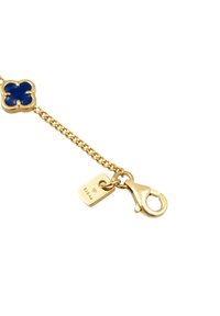 Armband aus goldfarbenem Metall mit einem blauen Blumenschmuckstück, einem Karabinerverschluss und einem kleinen Tag, der mit "925 Ag." graviert ist. Glatte, glänzende Oberfläche.