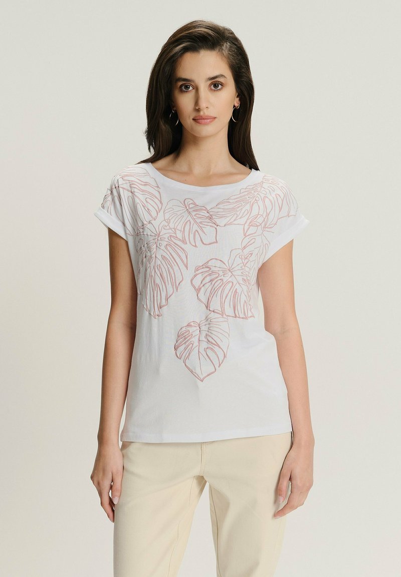 Biała koszulka o luźnym kroju, z różowym nadrukiem liści na przodzie, krótkimi rękawami i gładką fakturą.