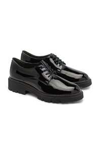 Zapatos de charol negros con punta redondeada, diseño de cordones y suela de goma gruesa que presenta un patrón texturizado alrededor del borde.