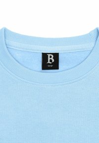 Lichtblauwe sweatshirt met geribde ronde hals. Bevat een zwart label met een witte "B" en het woord "large." Glad textuur en klassiek ontwerp.