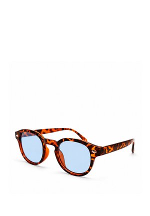 Sonnenbrille mit Schildpatt-Fassung, runden hellblau getönten Gläsern und einem Schlüssellochsteg auf weißem Hintergrund.