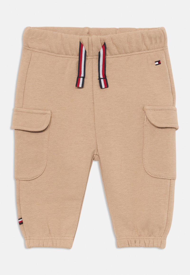 Pantalones joggers de algodón beige con cintura elástica, cordón en rojo, blanco y azul, y dos bolsillos laterales. Puño en el tobillo.