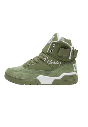 Baskets montantes vert olive avec lacets, bride velcro, accents blancs sur la semelle et broderie du logo "Patrick Ewing" sur le côté.