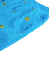 Pantaloni da bagno blu realizzati in tessuto leggero, con ricami di limoni arancioni, vita elasticizzata e tasche laterali con dettagli cuciti.