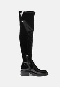 Botas negras hasta la rodilla de charol con una textura suave, que cuentan con un cierre lateral y una suela gruesa negra. Diseño sencillo y elegante.