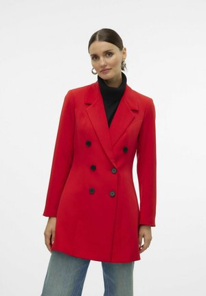 Red double-breasted blazer with black buttons, notched lapel, and long sleeves, paired with a black turtleneck and light blue jeans.