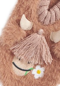 Accesoriu din pluș maro, având un zâmbet brodat, cu detalii inclusiv o floare și accente de blană. Material texturat și moale.