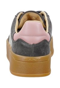 Sneaker in suede grigia con tallone in pelle rosa, dettagli beige e suola in gomma. Presenta un collare imbottito e il marchio "GANT" sulla suola.