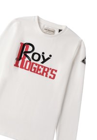 Weißes Langarm-T-Shirt mit fettgedrucktem schwarzen und roten Text: "Roy Roger's" und einer Gürtelgrafik. Etikett am Halsausschnitt sichtbar.