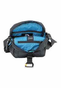 Bolsa de tela gris con apertura con cremallera, que cuenta con un forro de patrón contorneado azul, varios bolsillos interiores y una correa ajustable.