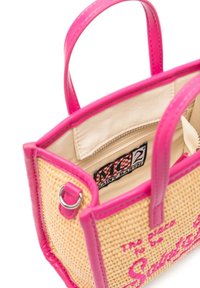 Woven straw handbag with fuchsia leather accents and handles. The interior features a zip pocket and brand label against a beige lining.