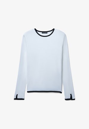 Weißer Strickpullover mit langen Ärmeln, kontrastierendem schwarzen Rundhalsausschnitt und Ärmelsäumen, mit kleinen seitlichen Schlitzen am Saum.