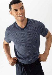 Navy V-neck t-shirt with a small white dot pattern. Short sleeves, lightweight fabric, and a contrasting collar with a smooth texture.