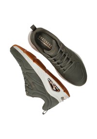 Zapatillas Skechers de color verde oliva con detalles de malla, diseño con cordones y suela de goma blanca que cuenta con un elemento de amortiguación de aire. Presenta acentos texturizados.