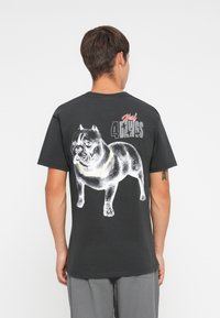 Black t-shirt featuring a white graphic of a bulldog on the back, with the text "Huf 4 the Dogs" in red and gray accents. Short sleeves.