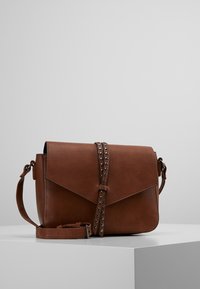 Brązowa skórzana torebka na ramię z klapką zapinającą, ozdobiona metalowymi ćwiekami wzdłuż paska. Gładka faktura, prostokątny kształt.