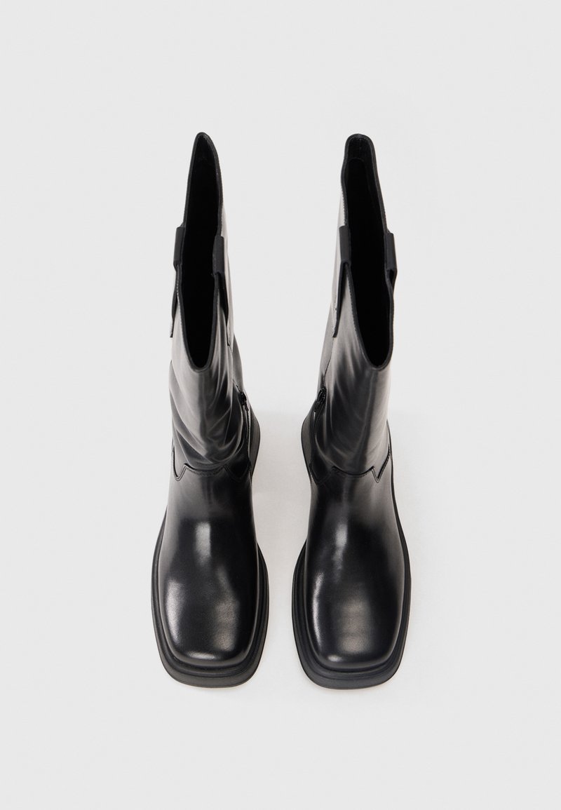 Schwarze Lederstiefeletten mit glatter Textur, rechteckiger Zehenpartie und Zuglaschenakzenten. Sie zeichnen sich durch ein minimales Design und eine robuste Plattformsohle aus.