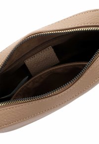 Beige leren pouch met structuur en een bovenste rits, met een bruine stoffen binnenkant en een klein binnenvakje met het merklabel "Tamaris".