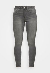 Jeans skinny cinzas escuros feitos de denim. Possui um design clássico de cinco bolsos, elementos em metal e um leve desbotamento no tecido para textura.