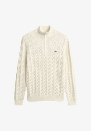 Cremefarvet strikket sweater med høj krave, der har kabelmønstre og halv lynlås lukning. Ribstrikkede manchetter og kant fuldender designet.