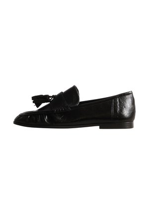 Mocassin en cuir noir avec pompon et talon bas, présenté de profil sur fond blanc.