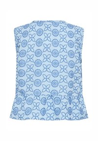 Haut bleu clair sans manches avec un motif floral et circulaire bleu, présentant un détail de bas à volants.