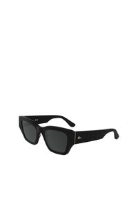 Lunettes de soleil noires avec une monture carrée, des verres foncés et des branches noires texturées présentant un motif subtil, ainsi qu'un accent de logo doré.