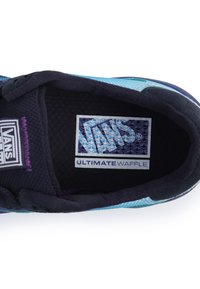 Interiér tenisky Vans s modro-černou-fialovou designem; obsahuje logo "Ultimate Waffle" a texturovanou tkaninu.