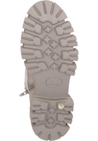 La semelle en caoutchouc grise de la botte présente des profondes stries, offrant une bonne adhérence. Elle inclut un motif en zigzag et des formes d'étoiles, avec un détail de logo visible.