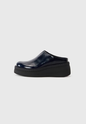Navyblauwe gepatenteerde lederen klomp met een gladde afwerking, voorzien van een dikke zwarte platformzool en zichtbare stiksels langs de onderkant.