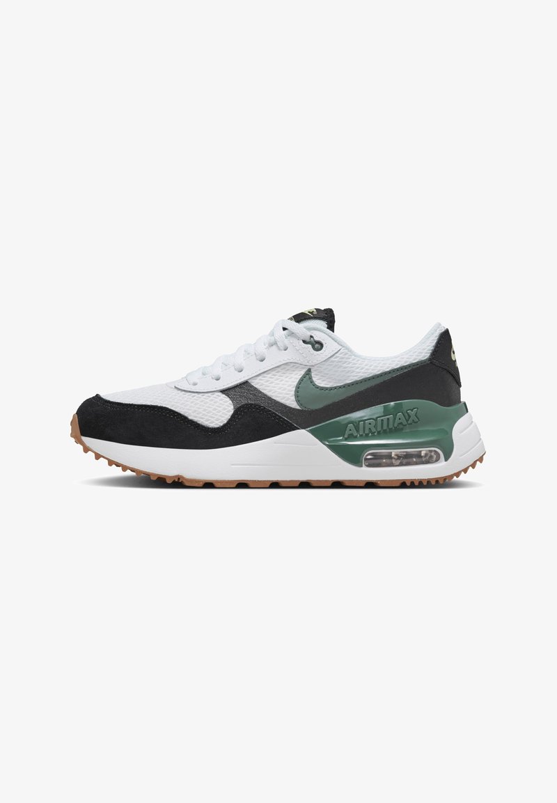 Tige en maille blanche avec des accents en daim noir, swoosh Nike vert et semelle intermédiaire blanche comportant une unité Air visible. Semelle extérieure en caoutchouc marron.
