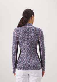 Langermet tettsittende topp laget av mønstret stoff i nyanser av blått og rosa, med høy krage og svarte sidepaneler.