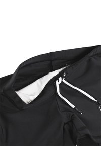 Melnā sporta topa izstrāde, kas izgatavota no gludas auduma, ar baltu iekšējo oderi, elastīgu auklu un kontrastējošiem šuvju elementiem.