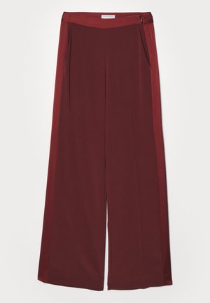 Pantalones de pierna ancha burdeos con una textura suave y lisa, que cuentan con una cinturilla plana y bolsillos laterales. Diseño minimalista sin hardware visible.