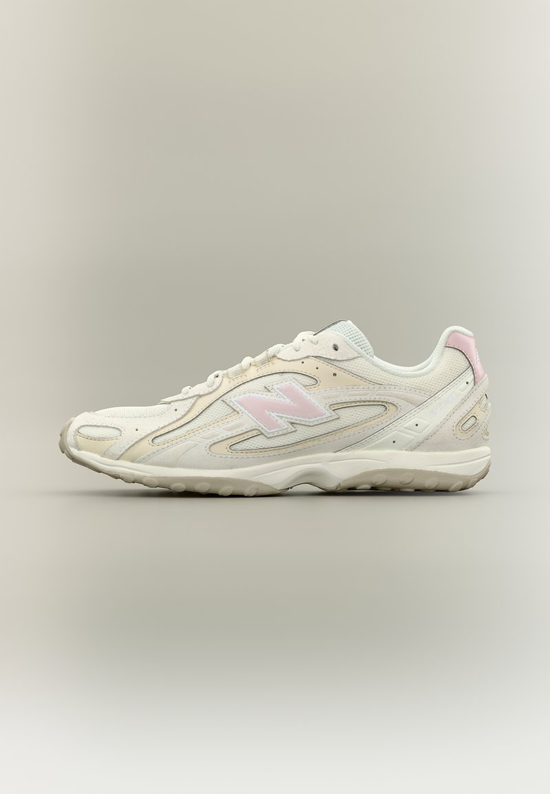 Baskets New Balance blanches et rose clair avec des détails en mesh et en daim, montrées de profil sur un fond neutre.