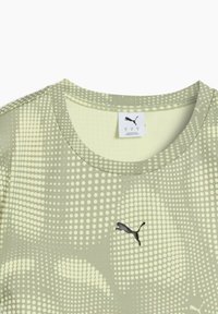 Heled roheline sportlik särk, millel on täpiline muster ja must Puma logo rinna peal. Krae on ümmargune ja materjal näeb välja pehme.